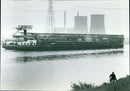 A Roll-on/Roll-off barge carrying 600 cars on its way to Born, Netherlands, has to choose alternative routes due to its height, as it cannot fit under all the viaducts. - Vintage Photograph
