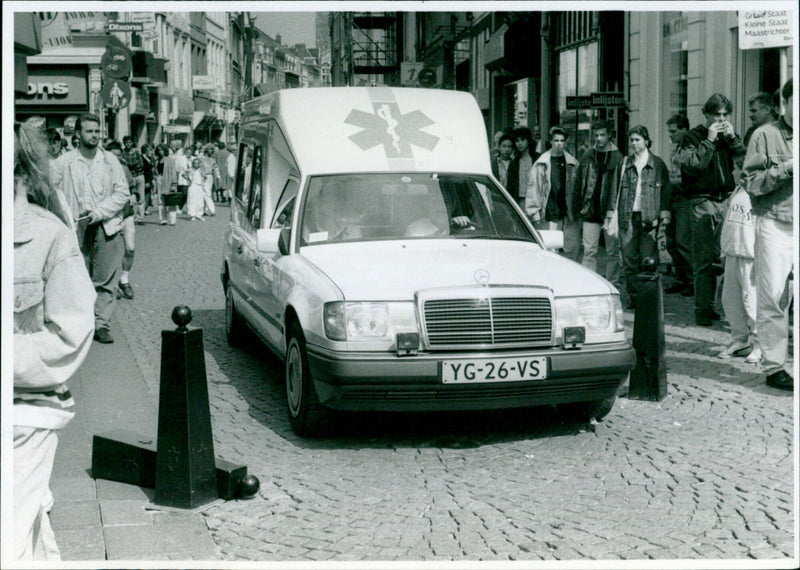 A Maastricht ambulance driver removes a hindering bollard to continue their journey. - Vintage Photograph