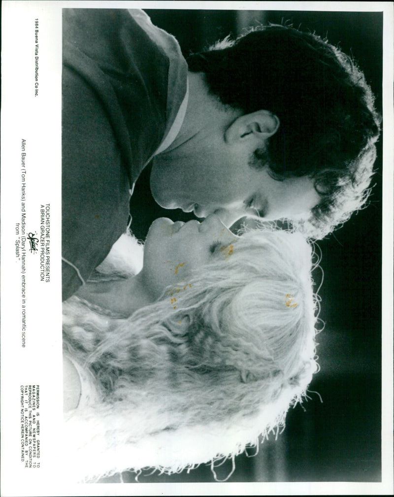 Tom Hanks and Daryl Hannah embrace in a romantic scene from the 1984 movie "Splash". - Vintage Photograph