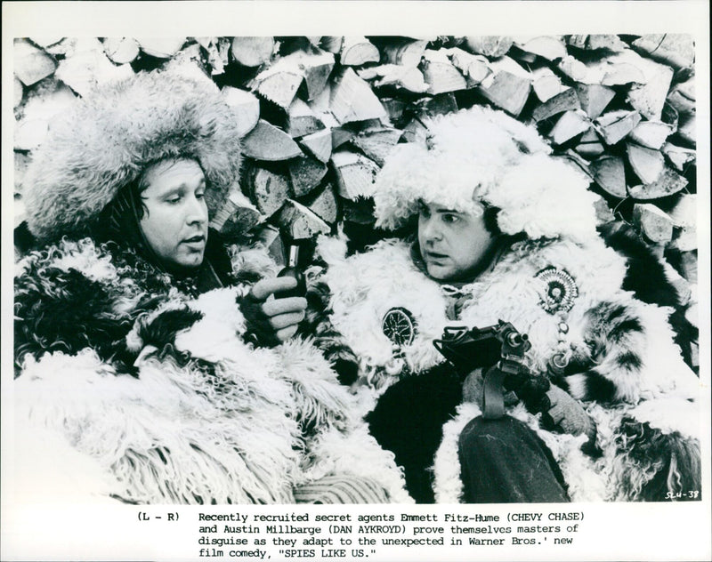 Recently recruited secret agents Emmett Fitz-Hume and Austin Millbarge prove themselves masters of disguise in Warner Bros.' new film comedy, "Spies Like Us." - Vintage Photograph