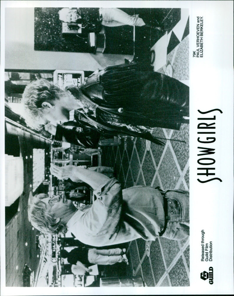 Paul Verhoeven and Elizabeth Berkeley pose with the cast of the film Showgirls. - Vintage Photograph