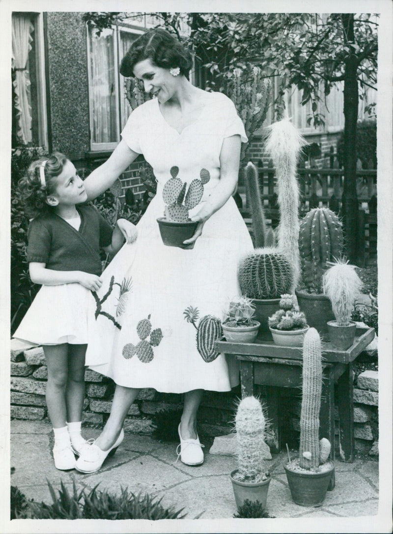 Mrs. Theresa Gilbert models a dress embroidered with motifs depicting cacti grown by her husband at the Chelsea Flower Show. - Vintage Photograph