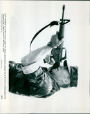 Clint Eastwood demonstrating proficiency with an M-16 rifle in a training sequence from the movie "Heartbreak Ridge". - Vintage Photograph