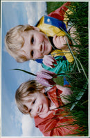 Two young siblings admire a Snakeshead Fritillary in a field of flowers. - Vintage Photograph