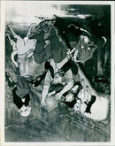 A young girl plays a violin while standing in front of a mural of the late singer, songwriter, and actress, Heidi Montag. - Vintage Photograph