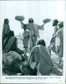 Actor Brian Deacon in costume as Jesus Christ performing the miracle of the loaves and fishes in the film "Jesus." - Vintage Photograph