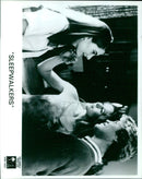 A group of people walking in a line in front of a movie theater. - Vintage Photograph