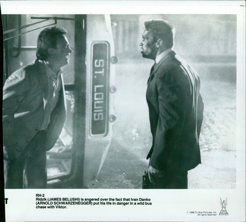 James Belushi is angered over the fact that Arnold Schwarzenegger has put his life in danger in the wild bus chase in the movie Red Heat. - Vintage Photograph