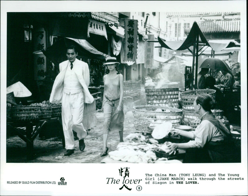 Tony Leung and Jane March walking through the streets of Saigon in the film The Lover. - Vintage Photograph