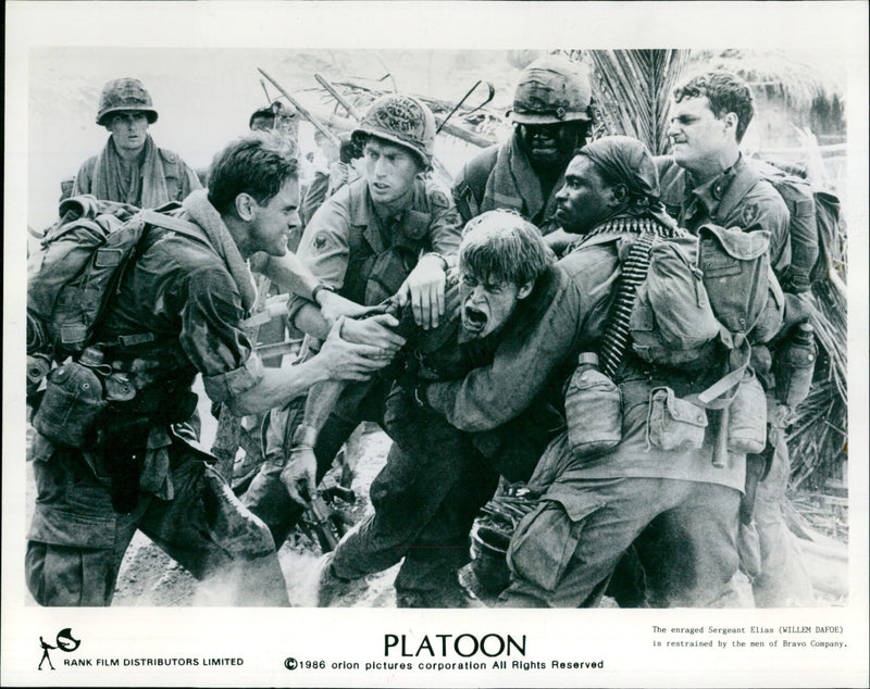 Sergeant Elias is restrained by the men of Bravo Company in the 1986 film Platoon. - Vintage Photograph