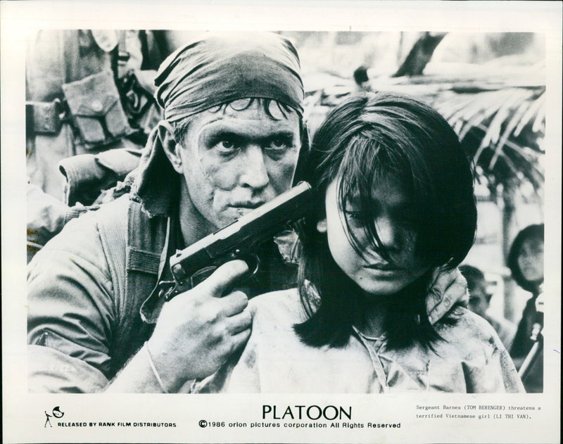 Sergeant Barnes (Tom Berenger) threatens a terrified Vietnamese girl (Li Thi Van) in the 1986 film Platoon. - Vintage Photograph