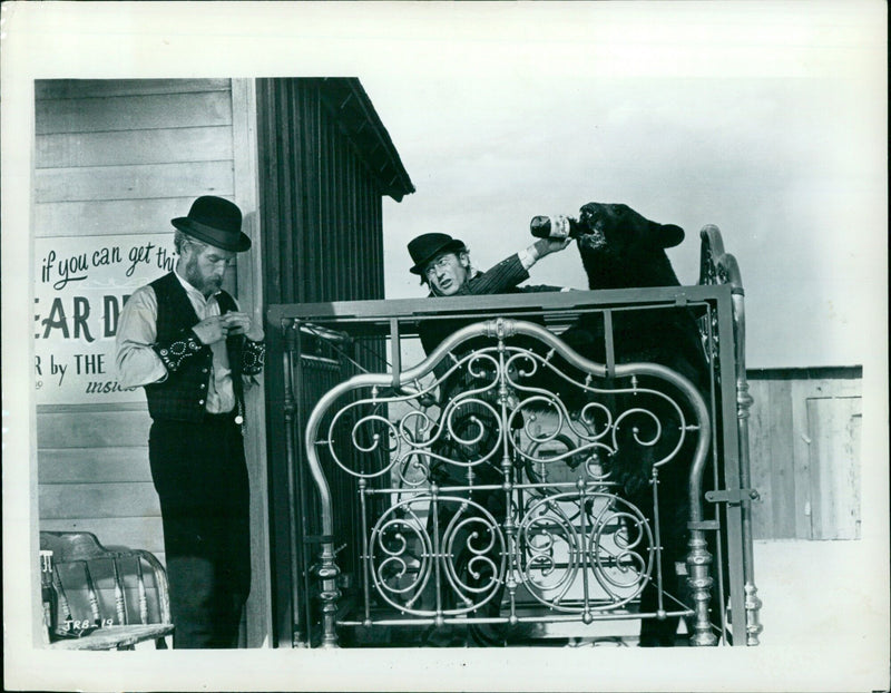 Paul Newman plays a cruel joke on Roddy McDowall in the film "The Life and Times of Judge Roy Bean". - Vintage Photograph
