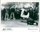 A crowd of people dance in the street in the 1984 film Beat Street. - Vintage Photograph