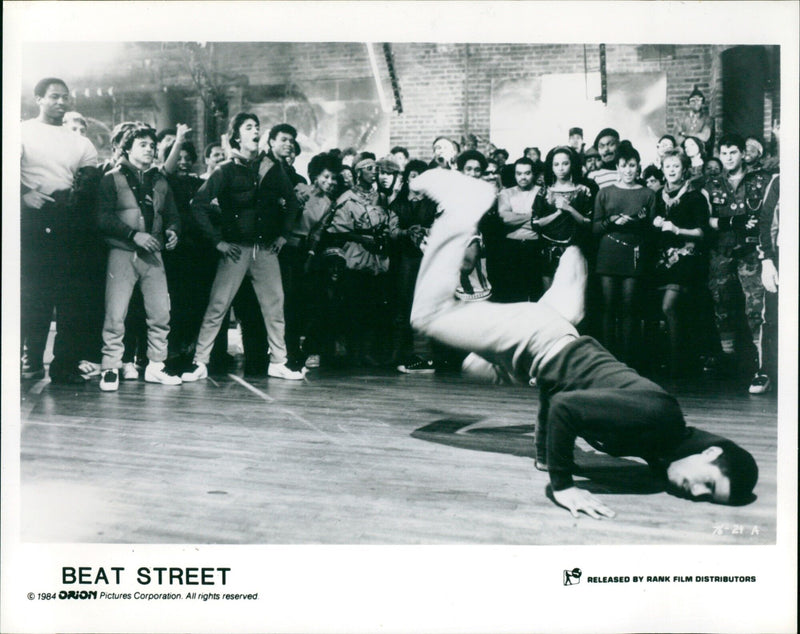 A crowd of people dance in the street in the 1984 film Beat Street. - Vintage Photograph