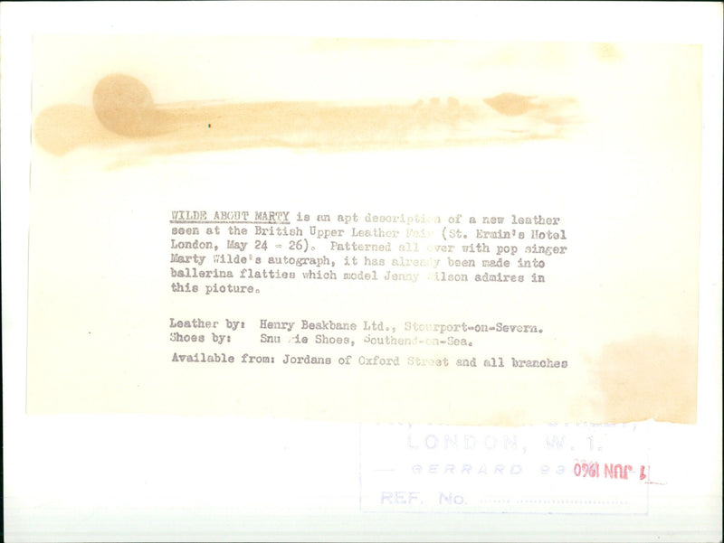 Model Jenny Wilson admires a new leather patterned with singer Marty Wilde's autograph. - Vintage Photograph