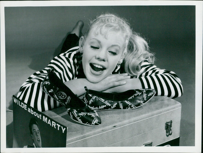 Model Jenny Wilson admires a new leather patterned with singer Marty Wilde's autograph. - Vintage Photograph