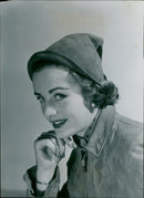 A model wearing a pixie-hooded tan suede creation from Agmar. - Vintage Photograph