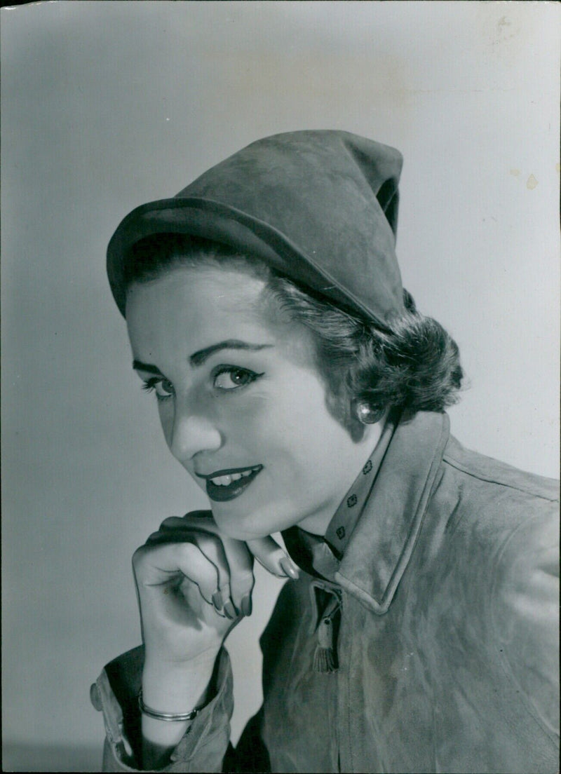 A model wearing a pixie-hooded tan suede creation from Agmar. - Vintage Photograph