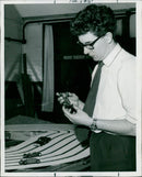 A Modelling Club member examines a miniature car he is making. - Vintage Photograph