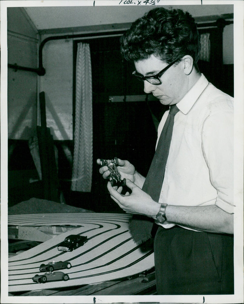 A Modelling Club member examines a miniature car he is making. - Vintage Photograph