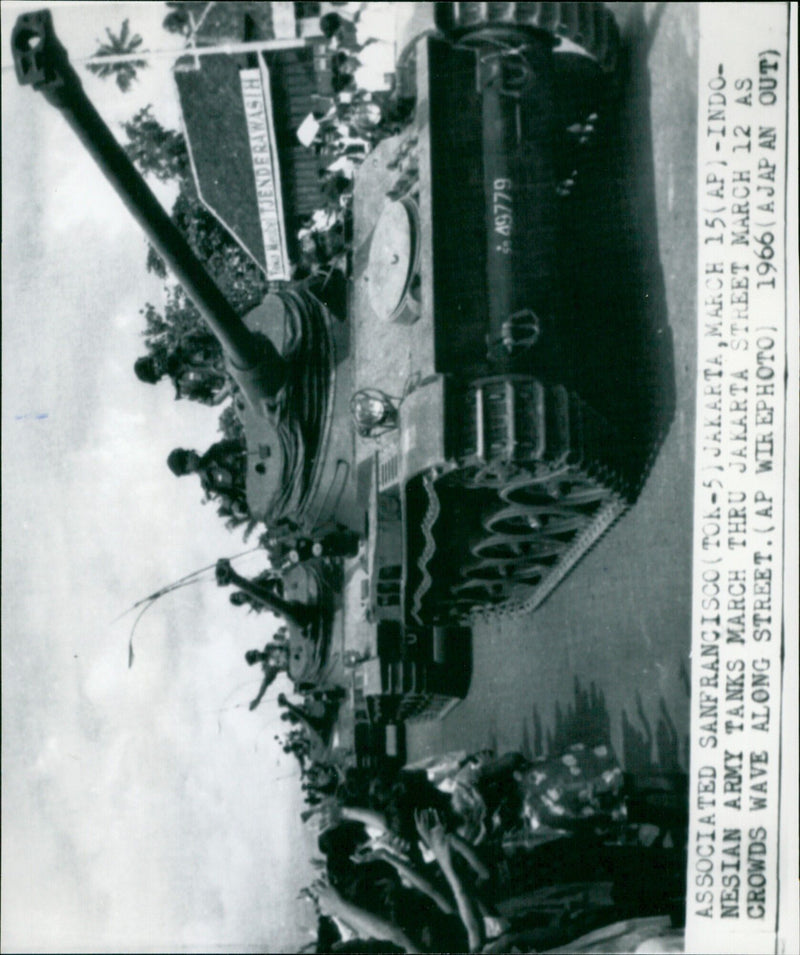 Indonesian army tanks march through a Jakarta street as crowds wave along. - Vintage Photograph