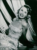 Actress Sheila Sim models a white brocade evening dress with a gold leaf motif. - Vintage Photograph