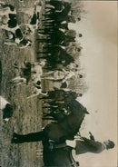 A young Afghan boy in traditional attire riding a donkey near a village. - Vintage Photograph