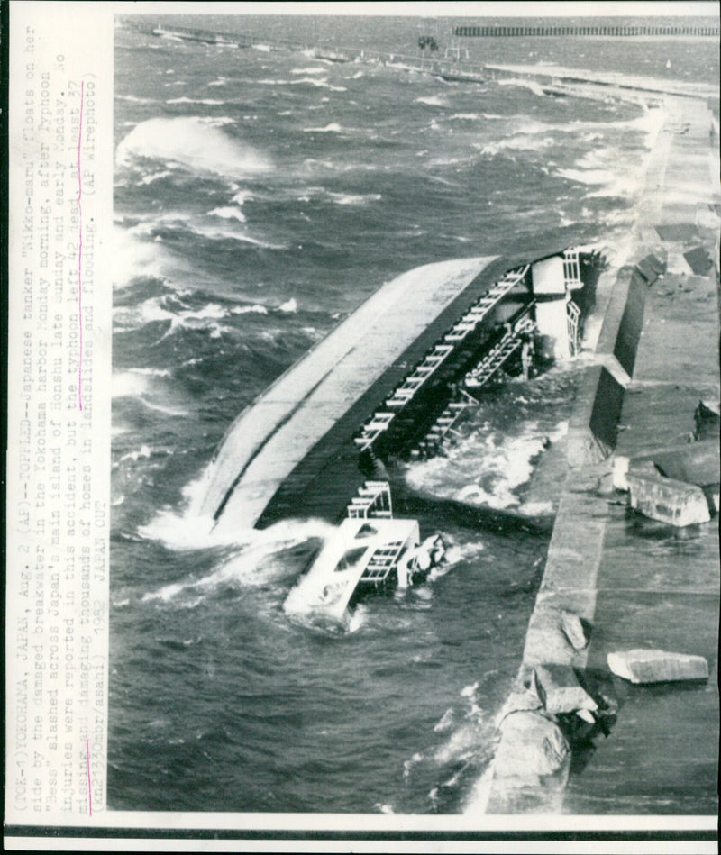 A Japanese tanker floats on its side in Yokohama Harbour after Typhoon Bess hit Japan's main island of Honshu. - Vintage Photograph
