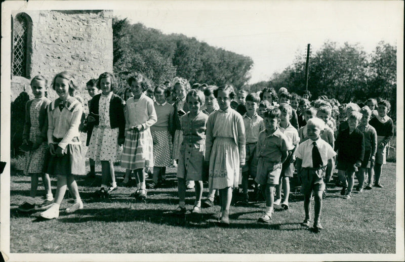A man rewinds a reel of film in a movie theater in 1957. - Vintage Photograph