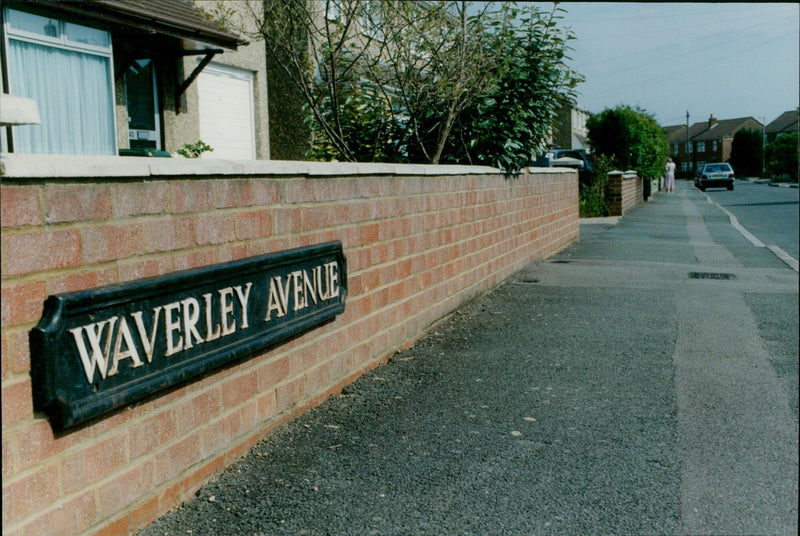 A young girl stands in the street in front of a house in Waverley Avenue. - Vintage Photograph