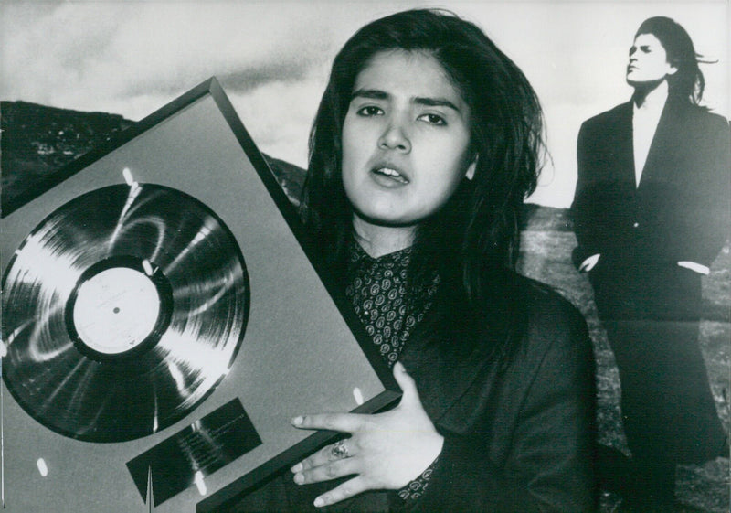 Tanita Tikaram proudly displays her first Gold Disc for her album "Ancient Heart", which has sold over 250,000 copies and spawned the hits "Good Tradition" and "Twist in My Sobriety". - Vintage Photograph