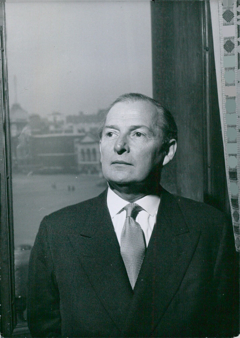 The Right Honourable Selwyn Lloyd, PC, CBE, QC, MP, Britain's Foreign Secretary, photographed in his office with part of the Admiralty building visible in the background. - Vintage Photograph