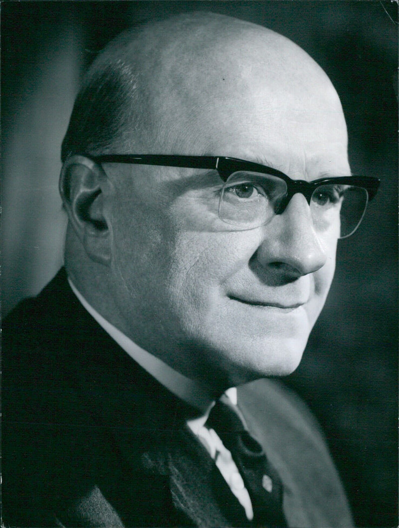 Sir Frank Rostron, Chairman of the Cotton Board since 1963, stands with an electro-engineering device from Ferranti Ltd, a company he is a director of. - Vintage Photograph