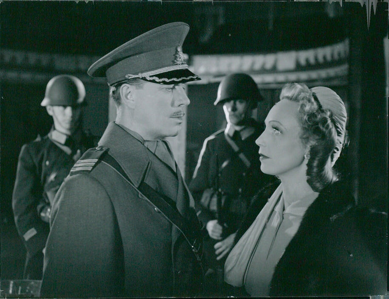 Lars Hansson and Inga Fidblad stand in front of a burning fire in Uldan, Sweden on February 2, 1943. - Vintage Photograph