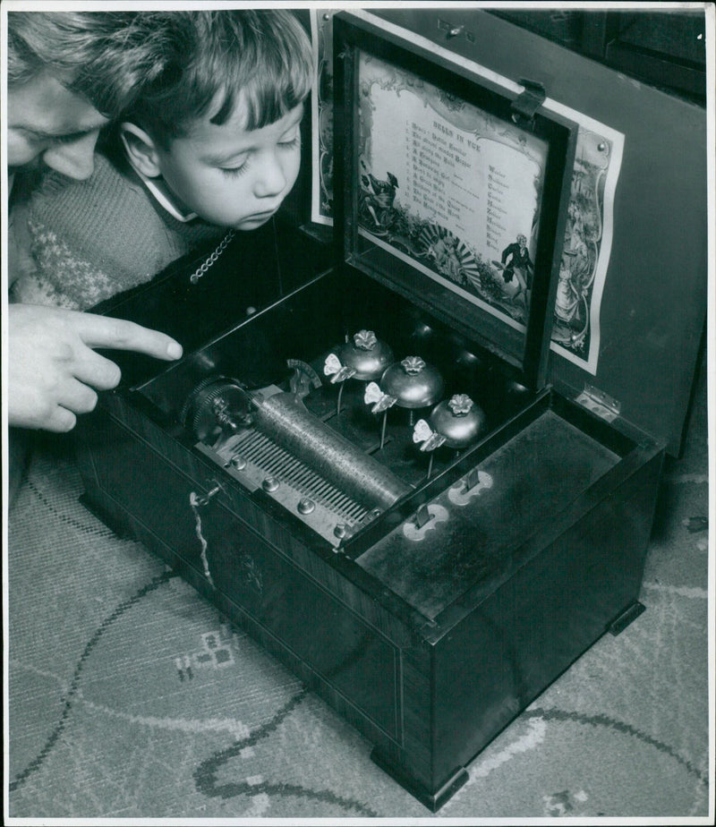 A young girl plays a musical box as soldiers and bells pass by on the railway in Brangosa, LA. - Vintage Photograph