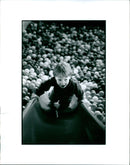 A medical professional holds a model of a brain while discussing the effects of epilepsy. - Vintage Photograph