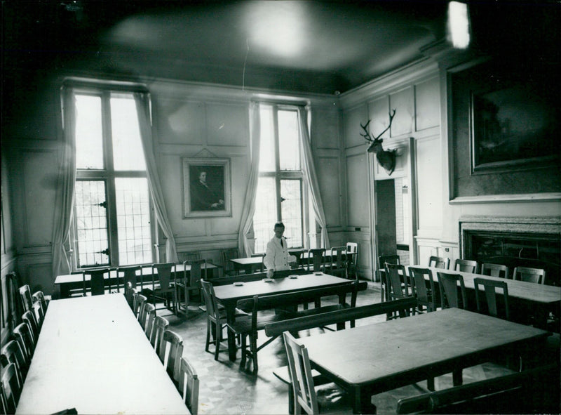 On September 23rd 1957, a waiter sets a table in the dining hall of Cheam School, where Prince Charles will become a pupil the following day. - Vintage Photograph