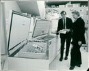 Mr. A.P. Paxman, freezer manager, explains different models of freezers to a customer at the Bejam Freezer Food Centre. - Vintage Photograph