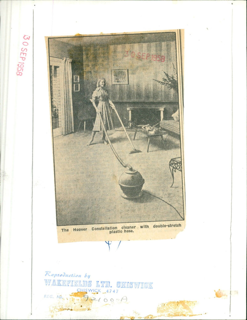 A Hoover Constellation cleaner with double-stretch plastic hose. - Vintage Photograph