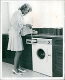 A woman demonstrating the new Hoover Automatic De Luxe Model A3006 vacuum cleaner. - Vintage Photograph