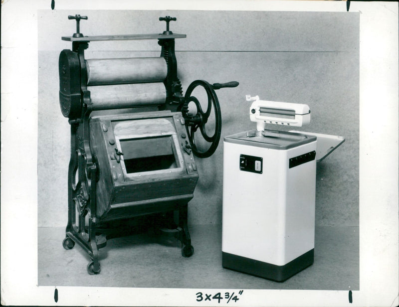 A side-by-side comparison of an early 19th century washing machine with a modern-day model. - Vintage Photograph