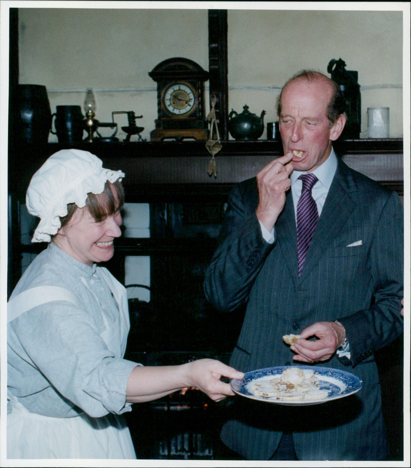 The Duke of Kent enjoys a scone during his visit to Cogges on March 7, 2000. - Vintage Photograph