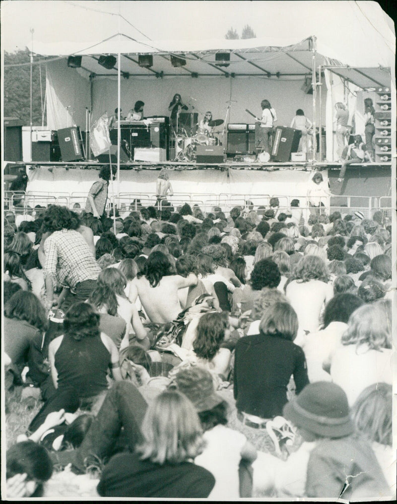 Thousands of music fans enjoy a summer day at a pop festival. - Vintage Photograph