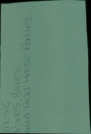 A man stands in front of a wall of music flyers and posters. - Vintage Photograph