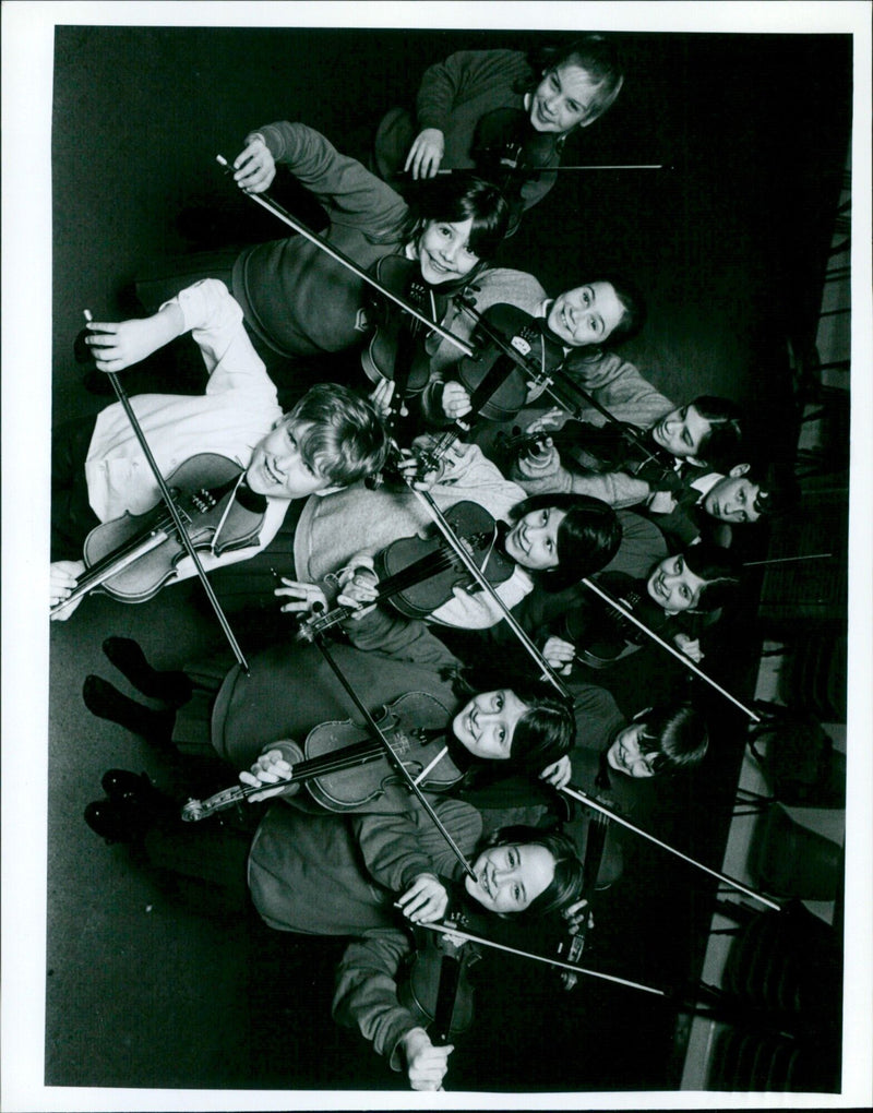 Music teacher Jill Cooper teaching 10-year-old student Lucy Demain the violin. - Vintage Photograph