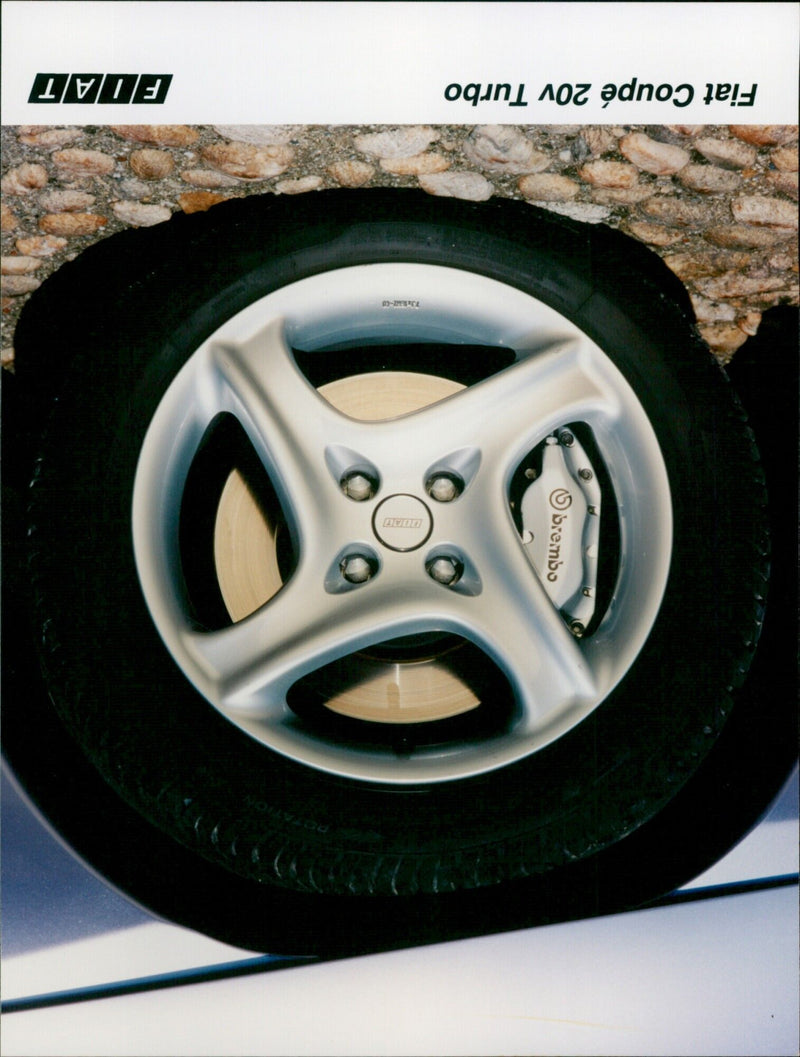 A Fiat Coupé 20v Turbo is seen in a parking lot. - Vintage Photograph