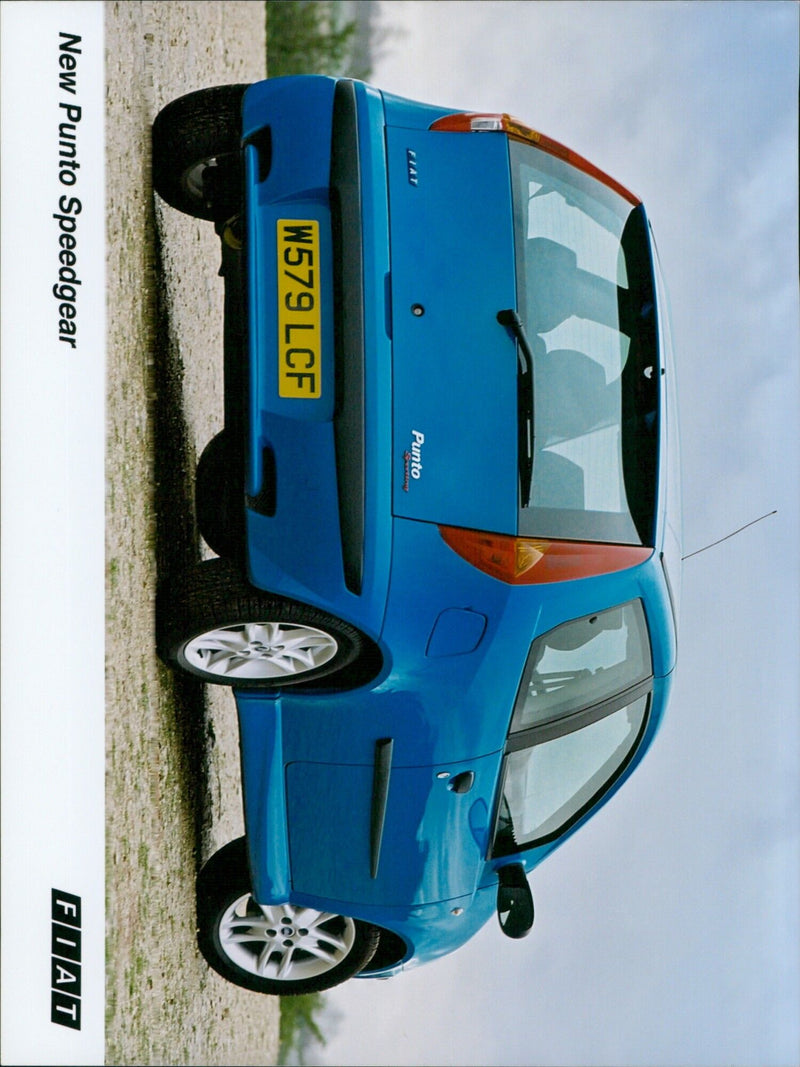 A new Fiat Punto car is being driven on a highway. - Vintage Photograph