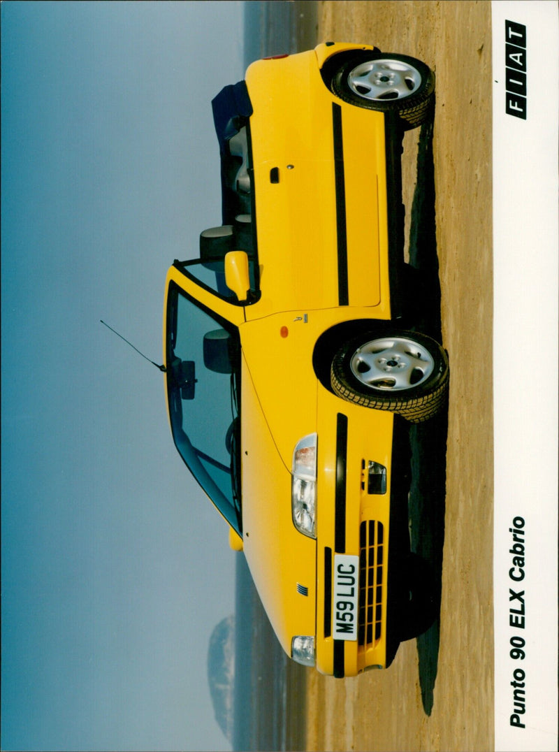 An M59 LUC Punto 90 ELX Cabrio FIAT OT car is seen parked in a residential street. - Vintage Photograph