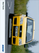 A red Fiat Punto IT drives along a country road. - Vintage Photograph