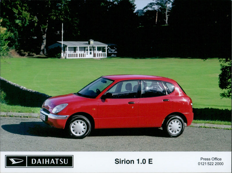 Daihatsu 7 Sirion 1.0 E car model displayed at a press event. - Vintage Photograph